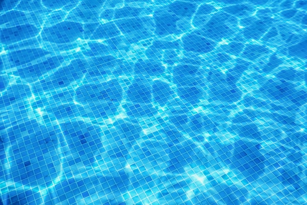 Azulejo azul da piscina subaquática, ondulações na água da piscina