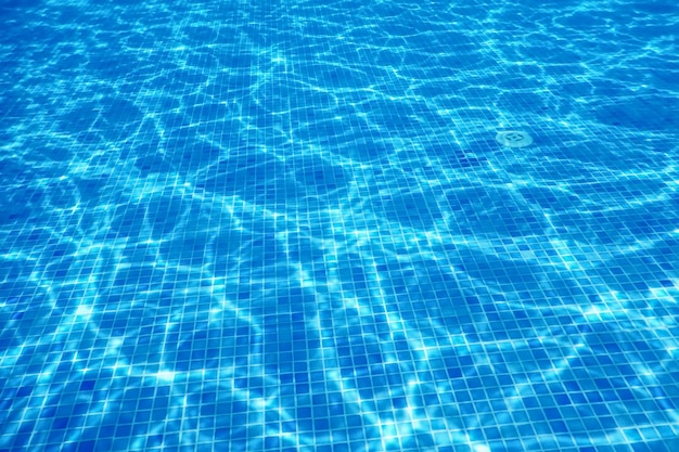 Azulejo azul da piscina subaquática, ondulações na água da piscina