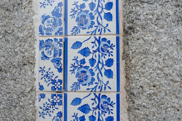 Foto azulejos florais vintage de cor branca e azul na fachada da parede de pedra no porto portugal