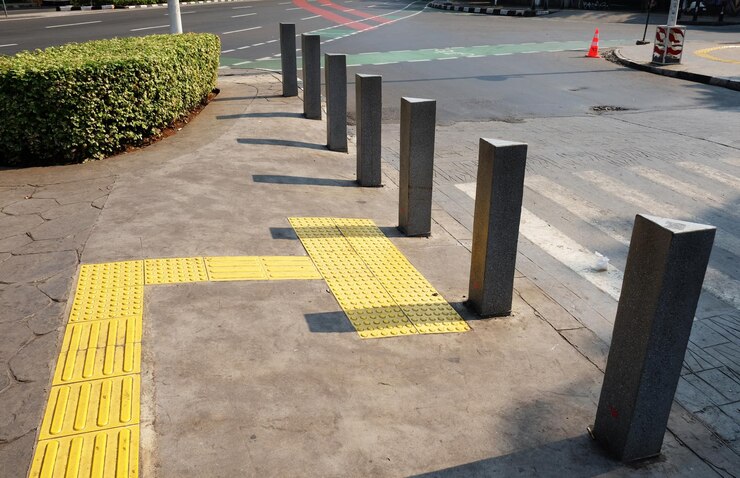 azulejos táctiles para discapacitados ciegos en un peatón para guiar a los ciegos usando caña al cruce de la carretera