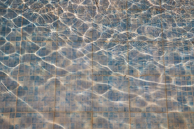 Azulejos viejos desvaídos en una piscina sucia como un