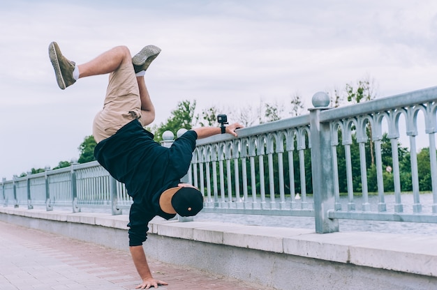 B-boy Break Dancer se para en un brazo con una cámara de acción.