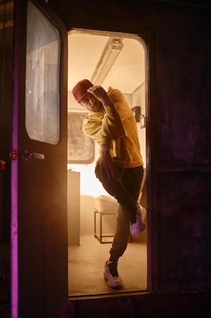 B-Boy-Breakdancer steht in einer gefrorenen Bewegung in der Tür des U-Bahn-Zugs