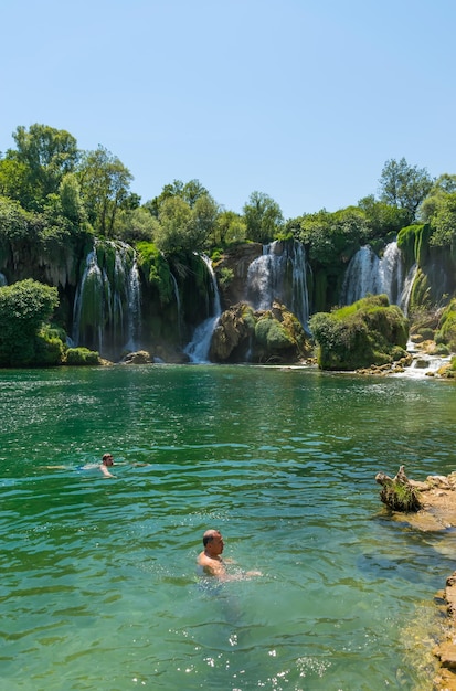 BÓSNIA E HERZEGOVINA, LYUBUSHKI. turistas descansam e nadam na pitoresca cachoeira
