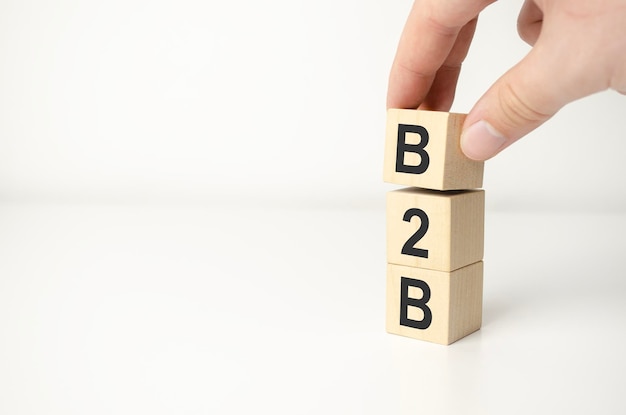 B2B-Abkürzung in Buchstaben auf Holzwürfeln Business-to-Business-Konzept Hand legte einen Würfel B in die Reihe