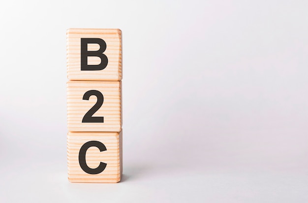 B2C-Buchstaben von Holzklötzen in Säulenform auf weißem Hintergrund, Kopienraum