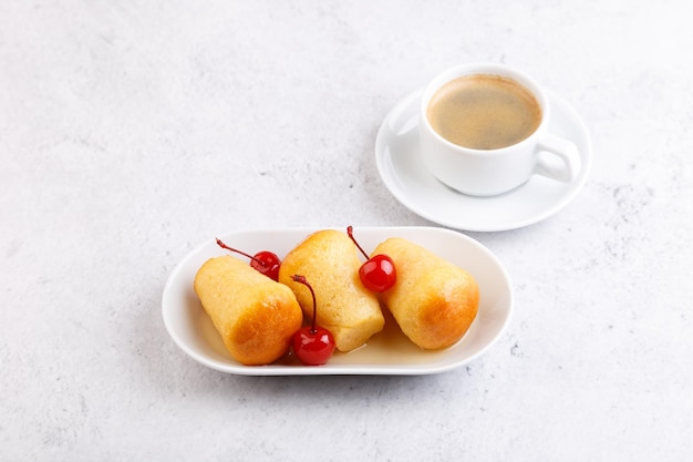 Baba de rum napolitano com cereja de coquetel pequenos bolos de fermento embebidos em calda de rum pastelaria italiana