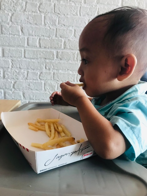 Foto babu disfruta de las papas fritas.