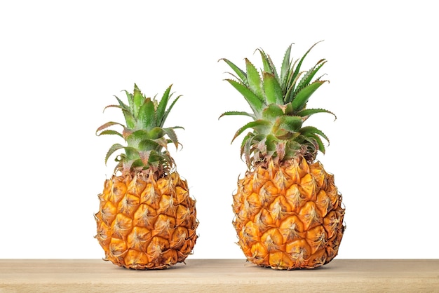 Baby-Ananas auf Holztisch mit isoliertem weißem Hintergrund.