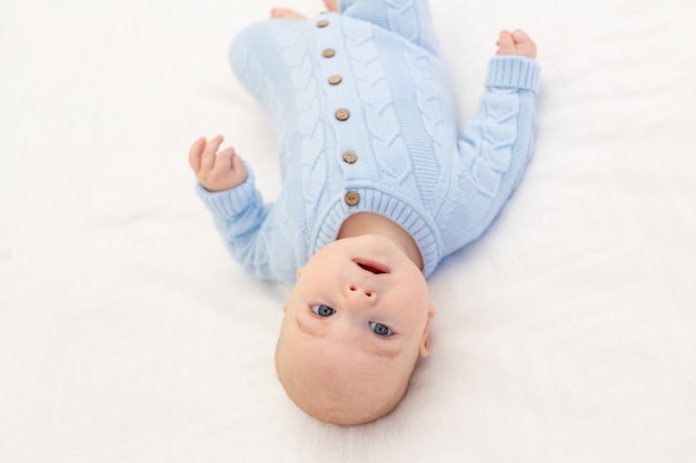 Baby auf dem Bett. Textilien und Bettwäsche für Kinder. Babys Morgen