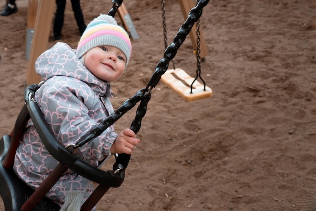 Baby auf Schaukel in Winterkleidung