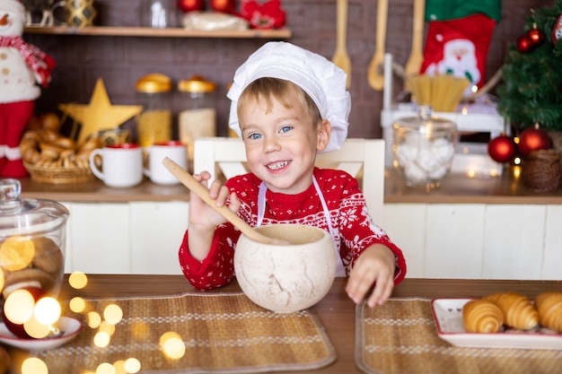 Baby backen Weihnachtsplätzchen in der gemütlichen Küche zu Hause Frohe Weihnachten und Neujahrsferienkonzept