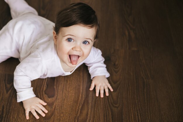 Baby Boy arrastrándose sobre un piso de madera