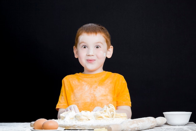 Baby Boy en la cocina mientras ayuda a cocinar