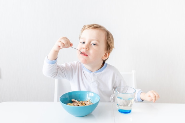 Baby Boy come con cuchara en casa, el concepto de alimentación y nutrición para niños