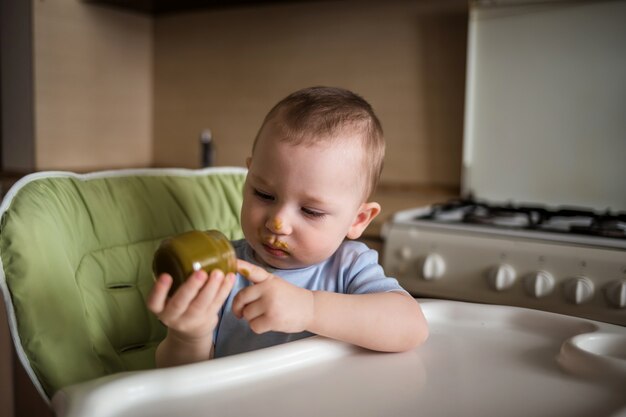 Foto baby boy comiendo en la cocina