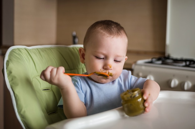 Foto baby boy comiendo en la cocina