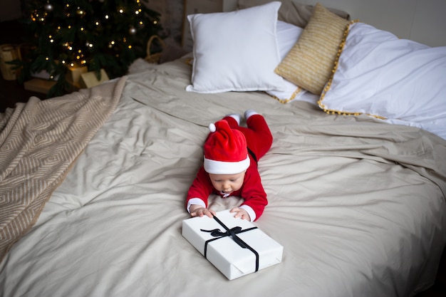 Baby Boy en un disfraz de Navidad con regalo