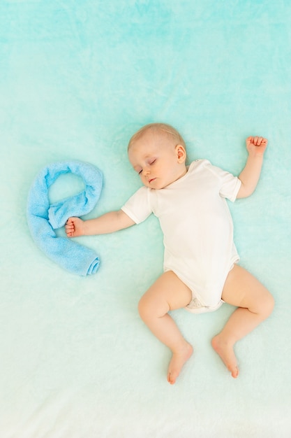 Baby Boy durmiendo con una gran letra E de una toalla