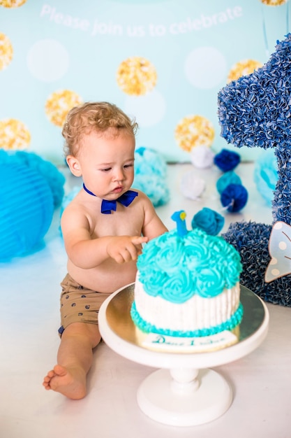 Baby Boy jugando con un pastel durante la fiesta de cumpleaños de cake smash