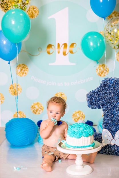 Baby Boy jugando con un pastel durante la fiesta de cumpleaños de cake smash