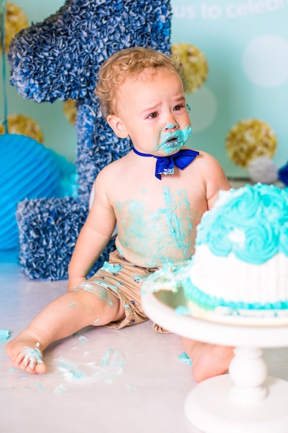 Baby Boy jugando con un pastel durante la fiesta de cumpleaños de cake smash