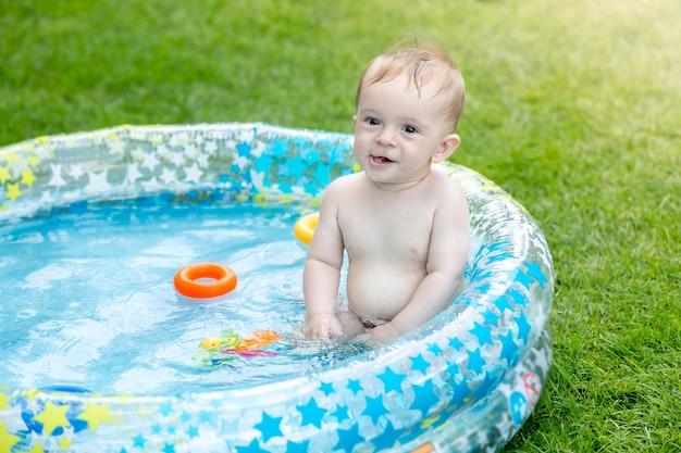 Baby Boy en la piscina inflable en el patio trasero