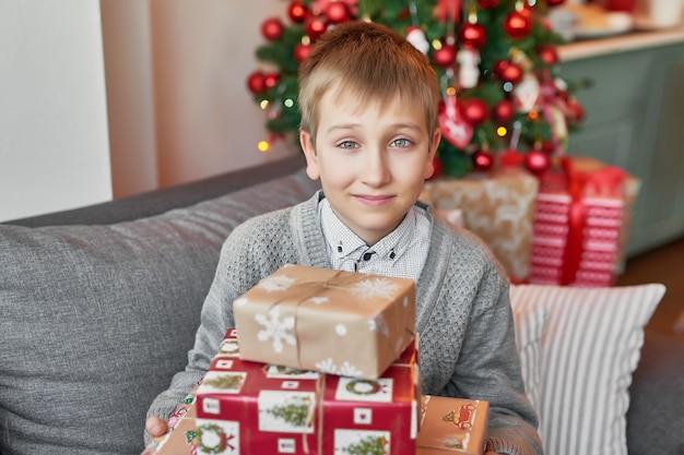 Baby Boy con regalos de Navidad en casa en la cama con decoración navideña