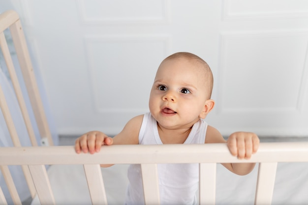 Baby Boy en ropa blanca en una cuna