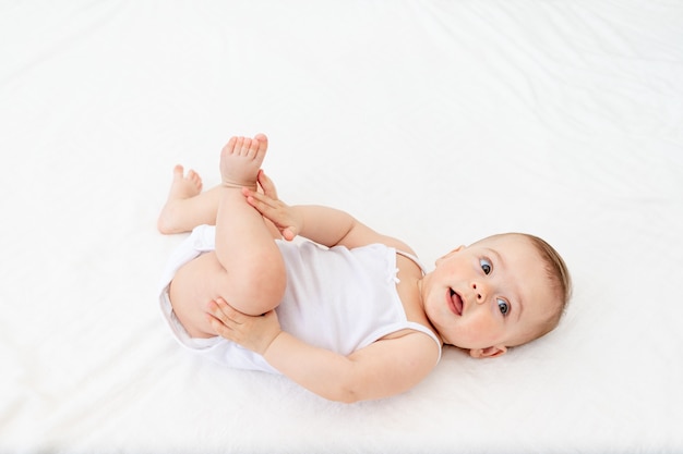 Baby Boy en ropa blanca en una cuna