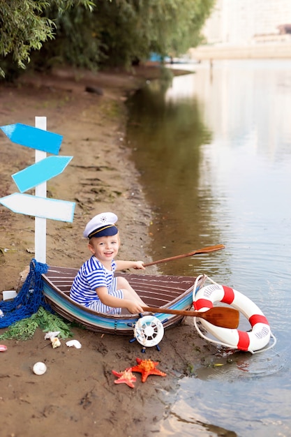 Baby Boy sentado en un barco en la playa