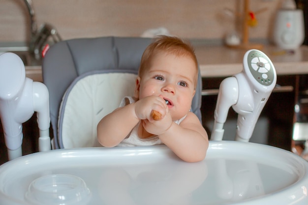 Baby Boy sentado en una silla alta en la cocina