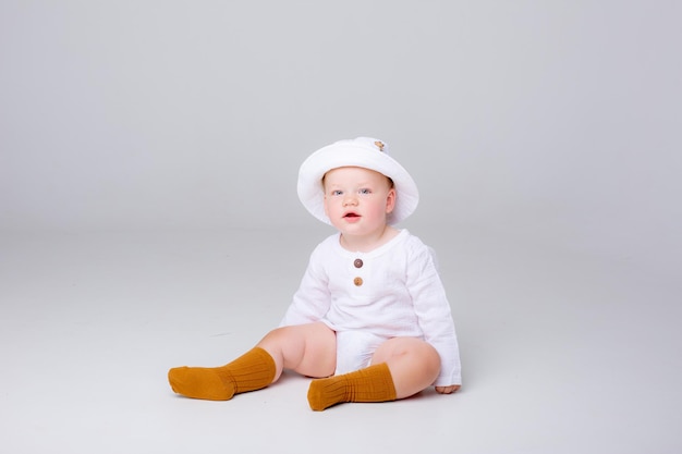 Baby Boy sentado sobre un fondo blanco en un sombrero de Panamá