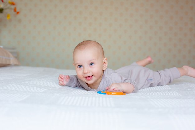 Baby Boy con un sonajero en la cama