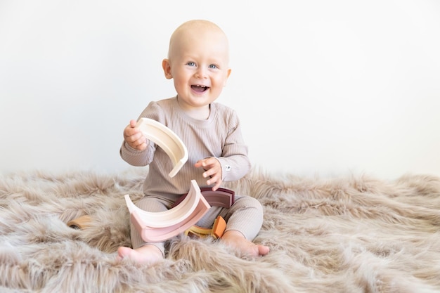 Baby Boy spielt mit pastellfarbenem Spielzeugregenbogen Montessori-Material für Feinmotorik Lernspiel für Kleinkinder