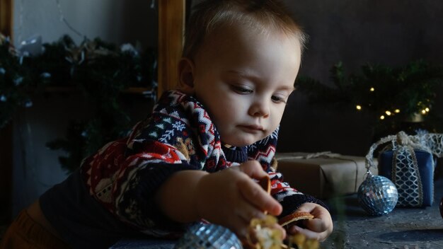 Baby Boy en suéter de Navidad en casa