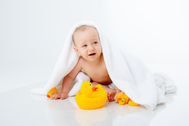 Baby Boy en una toalla después del baño sentado sobre un fondo blanco aislado