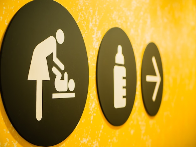 Baby Changing Room Sign y símbolo con fondo amarillo