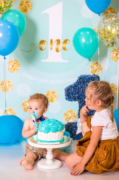 Baby, das mit einem Kuchen während der Kuchen zerschmettert Geburtstagsfeier spielt