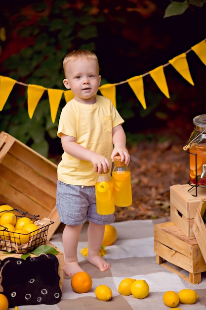 Baby, das Zitronen isst und Limonade im Freien beim Picknick trinkt