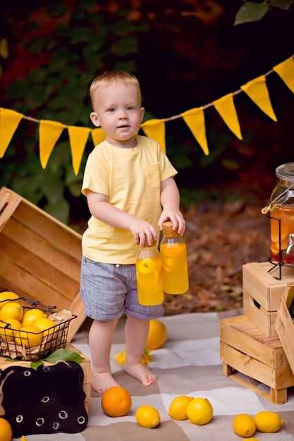 Baby, das zitronen isst und limonade im freien beim picknick trinkt