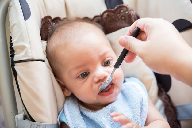 Baby eyed blue boy comiendo bebé bebé