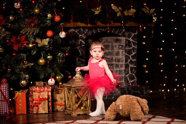 Baby feiert neues Jahr in der Nähe des Weihnachtsbaums zu Hause.