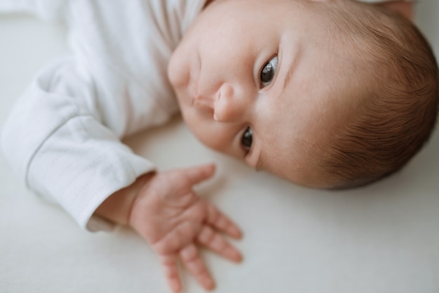 baby im weißen sonnigen schlafzimmer neugeborenes baby ruht im bett