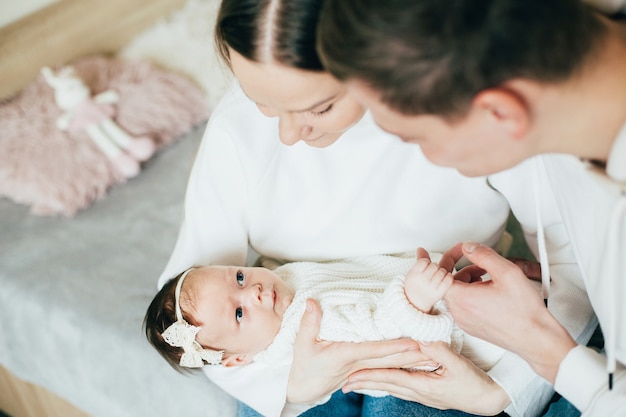 Baby in den Armen der Eltern im Zimmer