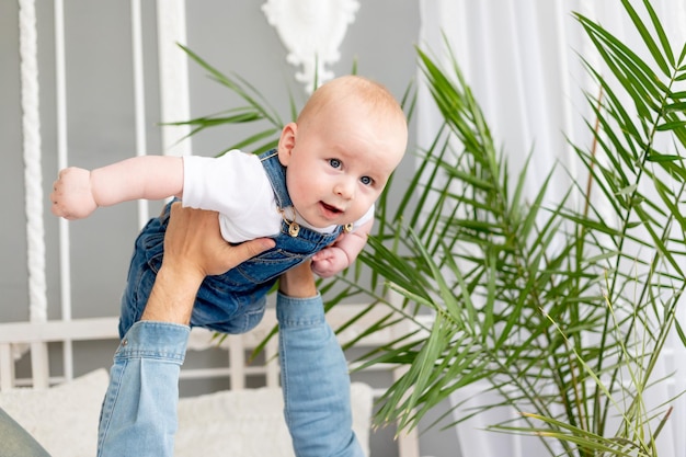 Baby in den Armen des Vaters, der Flugzeug spielt, glückliche Kindheit