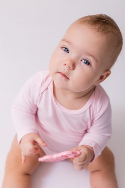 Baby in einem rosa Body sitzt auf dem Boden Draufsicht Platz für Text Hochwertiges Foto