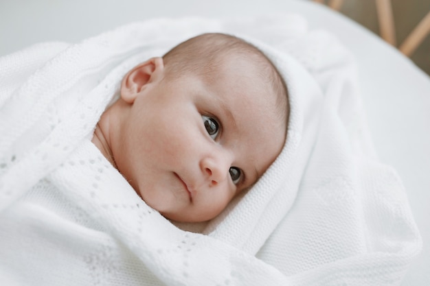 baby in einem weißen sonnigen schlafzimmer neugeborenes baby ruht im bett