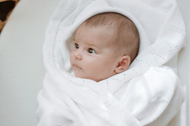 baby in einem weißen sonnigen schlafzimmer neugeborenes baby ruht im bett