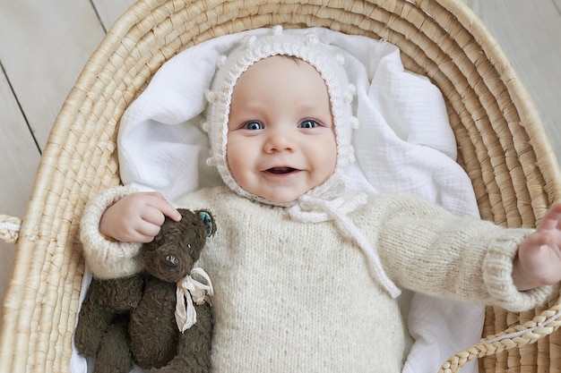 Baby in Korbwiege mit Holzspielzeug Muttertag Kinderschutztag Fröhliches Kind glückliche Kindheit